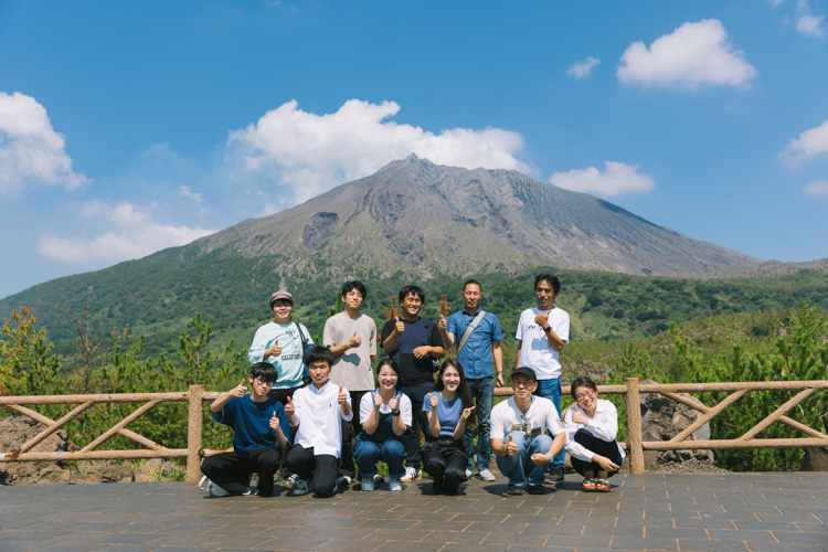 A group photo with Sakurajima in the background